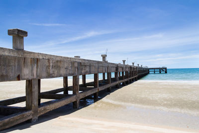 Pier on beach against sky