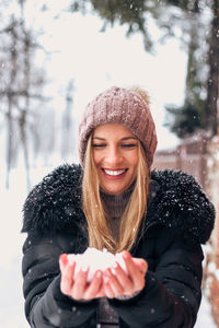 Portrait of smiling young woman in snow