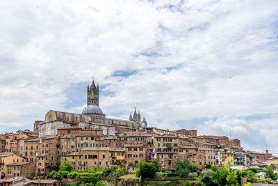 Duomo di siena in city against cloudy sky