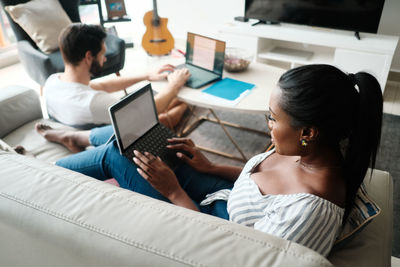 High angle view of man and woman working on laptop at home