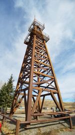 Low angle view of metallic structure on field against sky