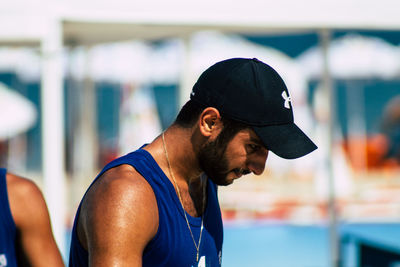 Side view of young man looking at camera