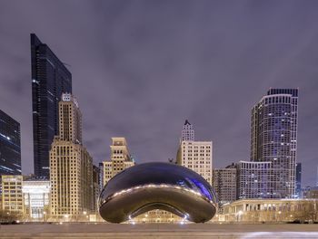 Illuminated cityscape against sky at night