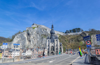 Saxophone bridge and notre dame de dinant church with citadel of dinant on the top of cliff