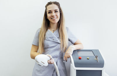 Portrait of young woman standing against white background