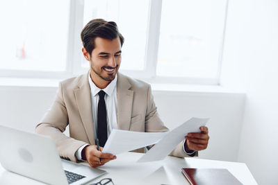 Portrait of businessman using digital tablet while standing in office