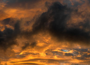 Low angle view of storm clouds in sky during sunset