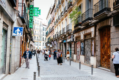 People walking on street amidst buildings in city