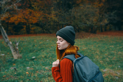 Young woman looking away while standing on land