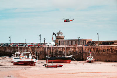 Ship moored in water against sky in city