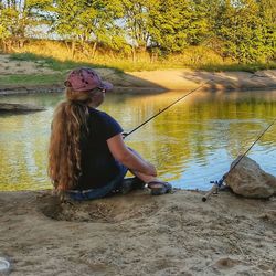 Young woman sitting on riverbank