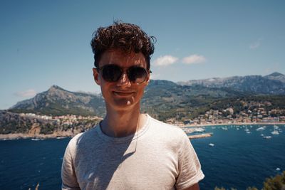 Portrait of smiling man in sunglasses against sea