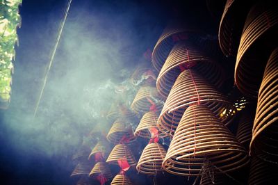 Low angle view of spiral incenses at temple