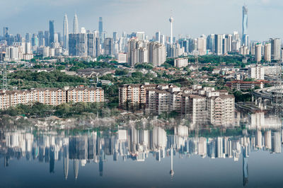 Reflection of buildings in city against sky