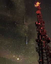 Low angle view of illuminated tower against sky at night