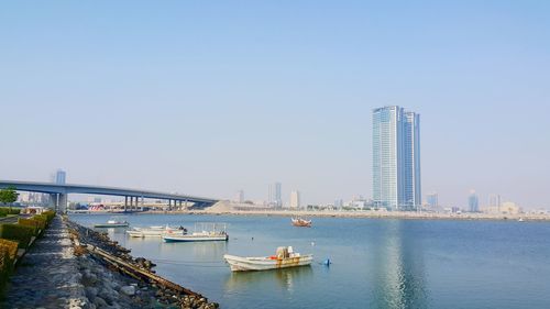 Bridge over river in city against clear sky