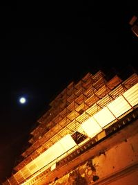 Low angle view of illuminated lights against sky at night