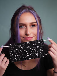 Portrait of a beautiful young woman holding camera