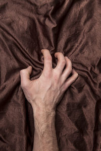 Directly above shot of woman hand on bed