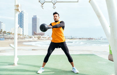 Determined athlete exercising with kettleball in gym