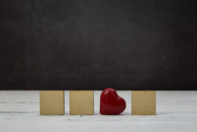 Close-up of heart shape on table against black background