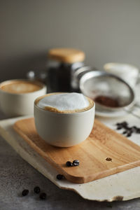 Close-up of coffee cup on cutting board