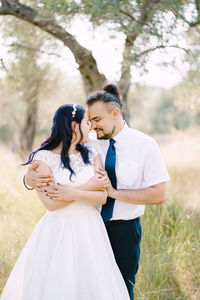 Low angle view of couple standing on field