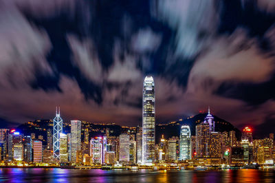 Illuminated buildings in city against sky at night