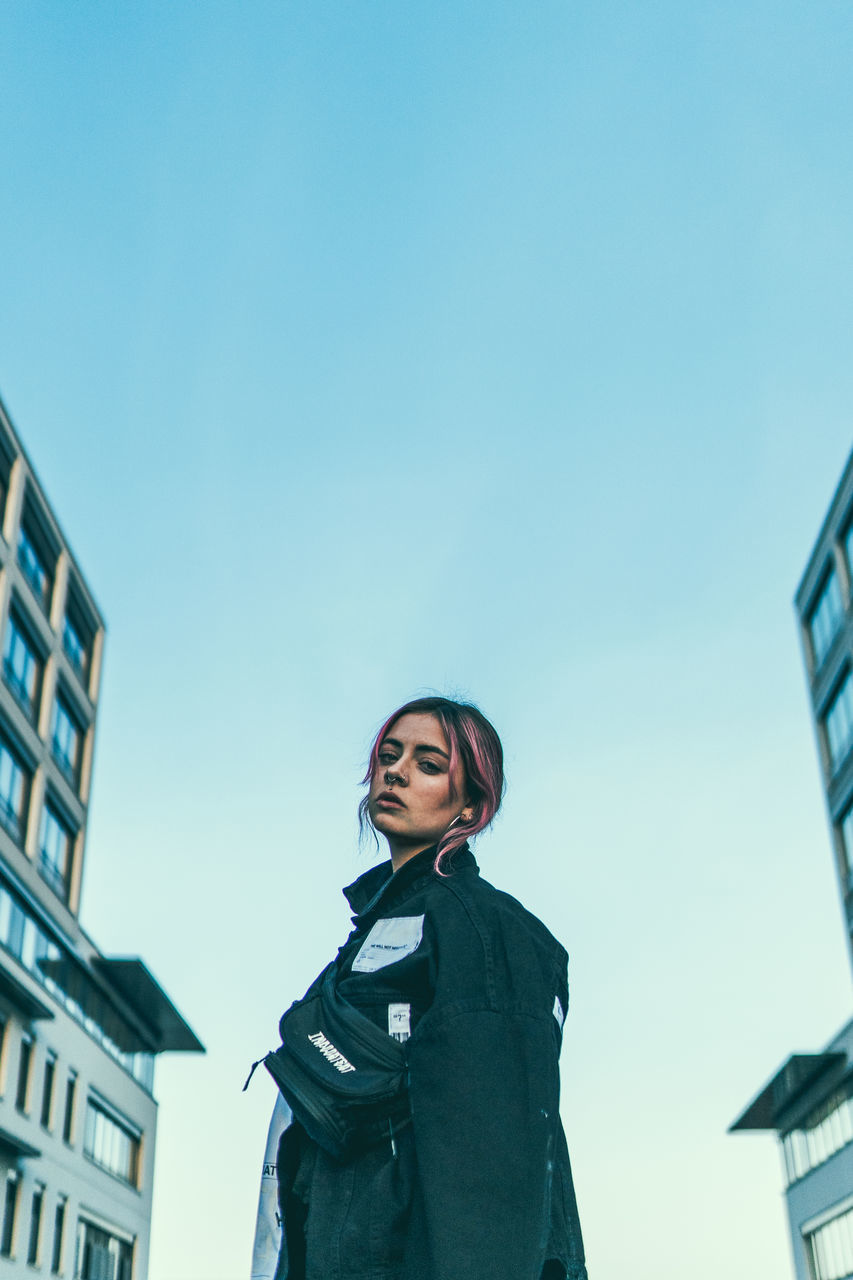 LOW ANGLE VIEW OF WOMAN AGAINST CLEAR SKY