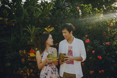 Couple talking while drinking coconut water at park