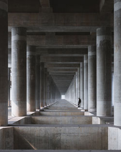 Man standing under bridge