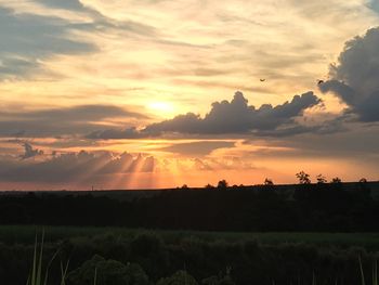 Scenic view of silhouette field against sky during sunset