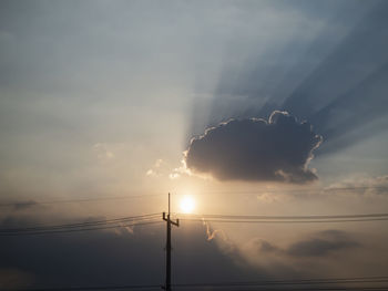 Low angle view of silhouette cables against sky during sunset