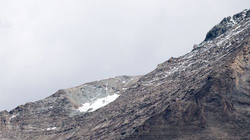 Low angle view of snowcapped mountain against sky