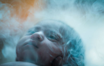 Close-up of baby girl amidst smoke