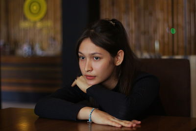 Portrait of teenage girl sitting on table