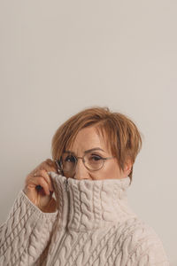 Portrait of woman wearing hat against white background