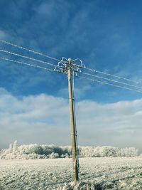 Low angle view of wind turbines against sky