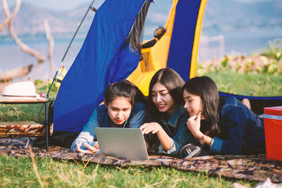 Group of friends sitting on tent