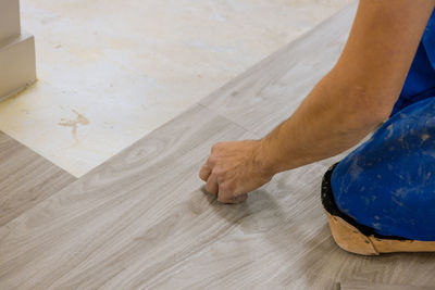 Cropped hand of person installing hardwood floor