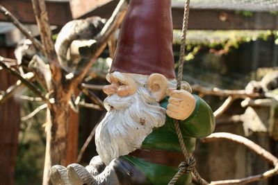 Close-up of gnome hanging on rope