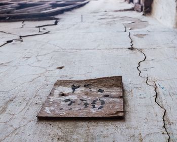 Close-up of wooden plank on cracked road