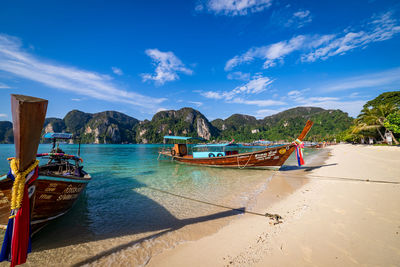 Boats moored on beach against sky