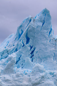 Close-up of snow on landscape against sky