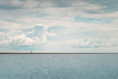 A man runs along the sea spit