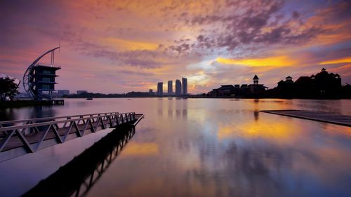 Scenic view of river against cloudy sky during sunset