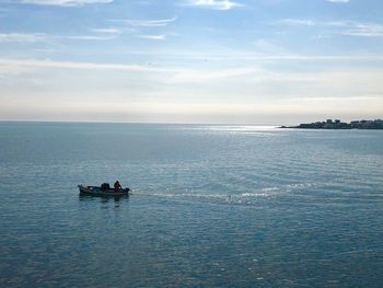 Motorboat in sea against sky