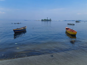Boat moored on sea against sky