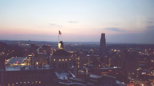 High angle view of city lit up at sunset