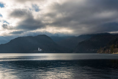 Scenic view of sea and mountains against sky